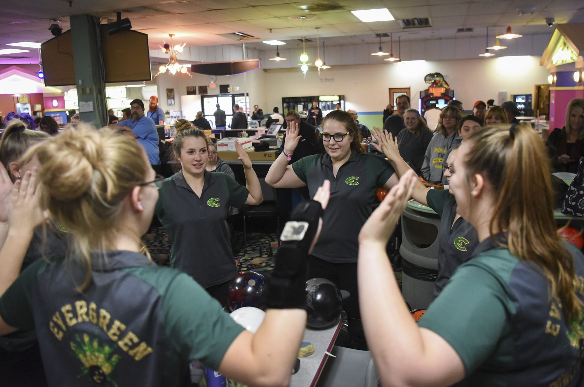 Evergreen bowlers high-five in a circle during the season opening jamboree at Crosley Lanes in Vancouver, Thursday November 9, 2017.