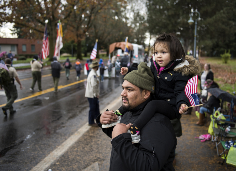 Miguel Vizcaino of Vancouver and his daughter Vanessa, 3, watch the annual Lough Legacy Veterans Parade at Fort Vancouver on Saturday. Miguel’s brother, Jose, served in the U.S. Marine Corps.