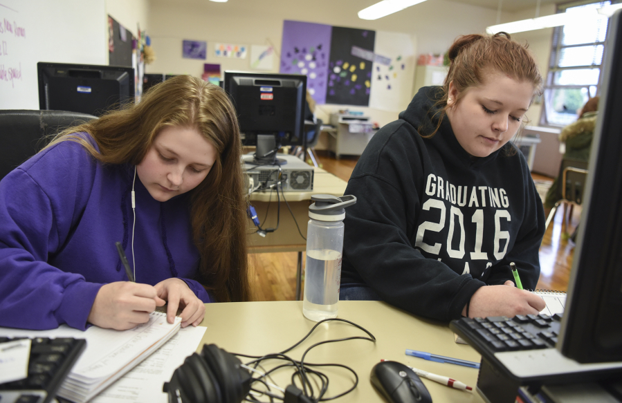 Chelseanne LaRue, 18, left, works on a math assignment next to her sister, Richland LaRue, 19, during their Open Doors Reengagement Program class, a re-entry program for students working to obtain their diploma after dropping out of high school. The sisters dropped out of school about two years ago after their family was homeless.