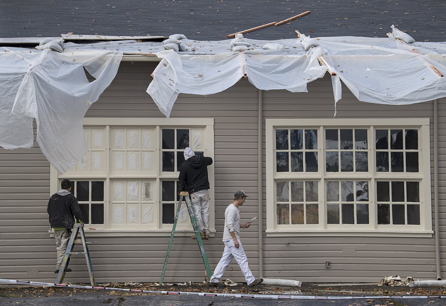Nathan Vernon, right, walks toward his work site Monday morning as a crew from Pro Paint Northwest renovates the former motor repair shop at Fort Vancouver National Historic Site. Built in 1919, it is one of five buildings in the East Barracks getting exterior makeovers.
