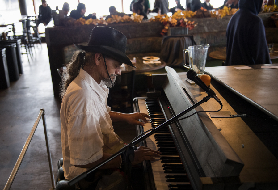 David Allen Welsh, currently homeless in Vancouver, plays the piano during the free Thanksgiving meal, hosted by state Court of Appeals Judge Rich Melnick, Chuck Chronis and Mark Matthias at WareHouse’ 23 in Vancouver on Thursday. Welsh played one of several songs he said he’s created in his mind.