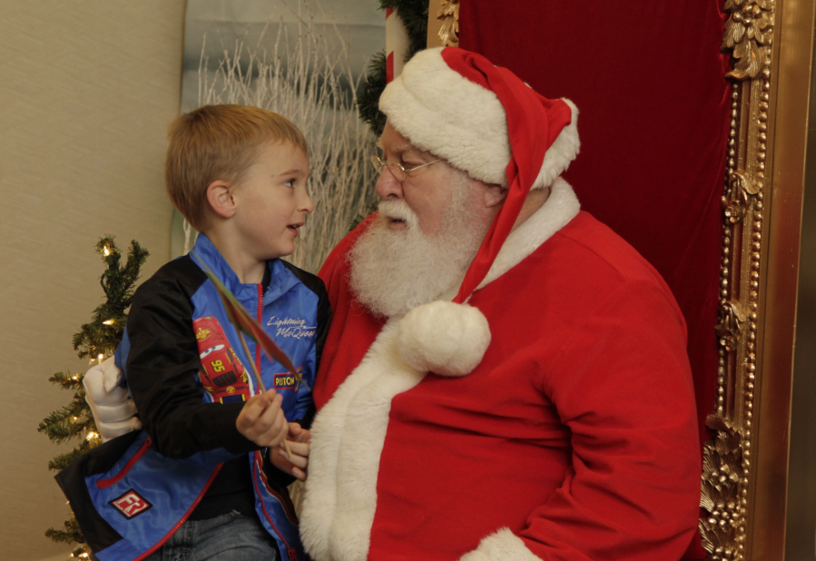 Five-year-old Owen McCart of Vancouver, left, makes his case to Santa Claus at the Vancouver Farmers Market’s Holiday Market Sunday afternoon.