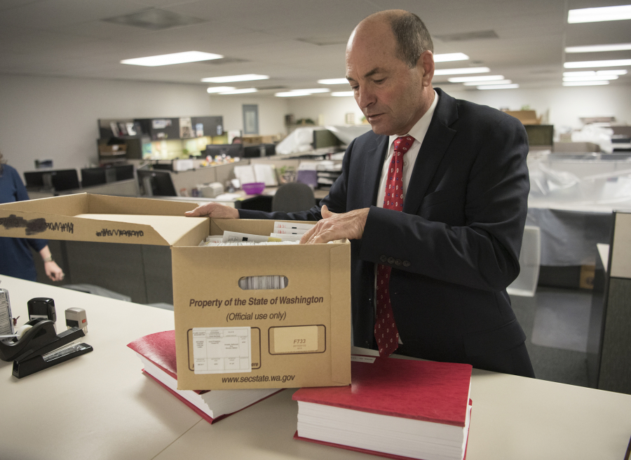Clark County Auditor Greg Kimsey opens a box containing archives of voter registration forms at the Clark County Elections Office. Kimsey’s office handles paperwork for voter registration, which is now becoming increasingly political.