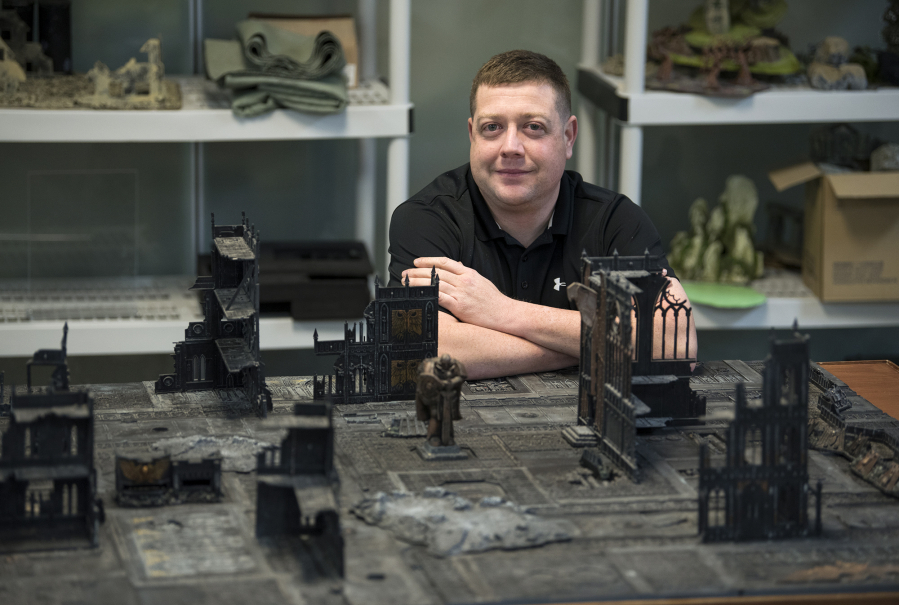 James Omelina sits next to a game of Warhammer 40,000 at Mythic Realm Games in Salmon Creek. Omelina designs increasingly popular escape rooms for Mythic Escapes, with a fourth escape room planned at Mythic Realm Games.