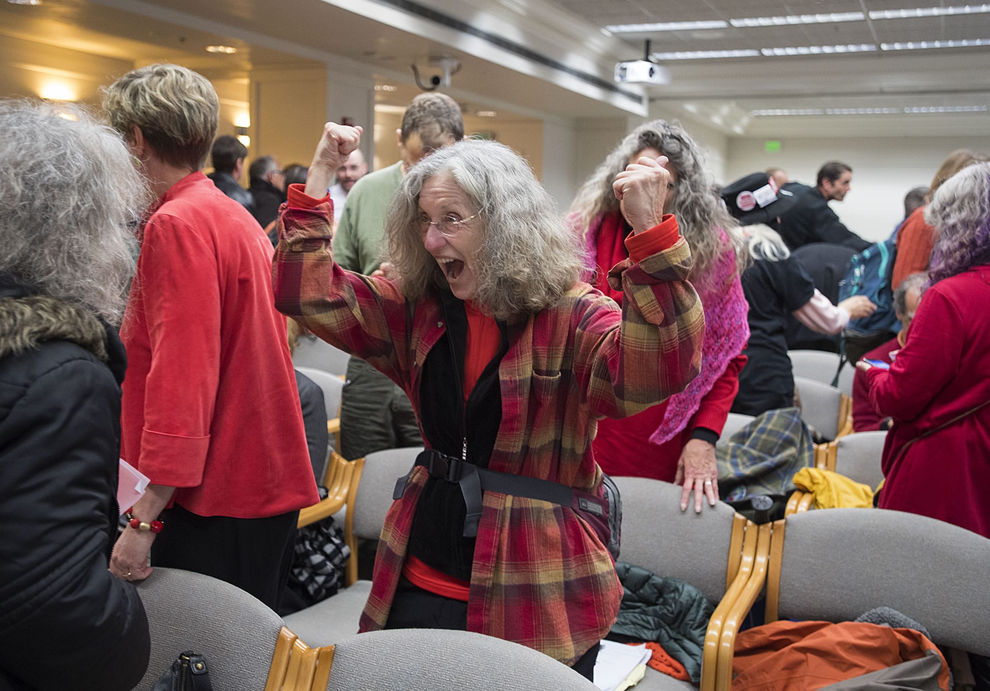 Carol Seaman of Citizens for a Clean Harbor, center, celebrates the EFSEC council ruling with fellow opponents of the Port of Vancouver oil terminal at the John A. Cherberg Building in Olympia on Tuesday afternoon, Nov. 28, 2017.