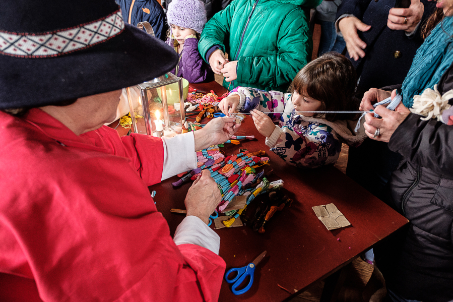 Four-year-old Kinsey Fleming, center, Beaverton, Ore., makes a tassle during the Christmas at the Fort celebration in 2016.
