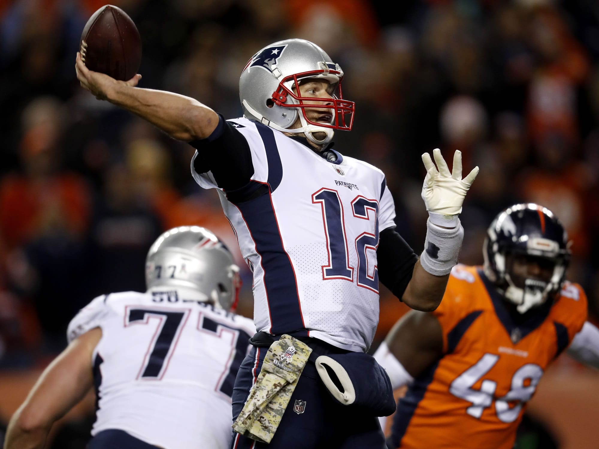 New England Patriots quarterback Tom Brady (12) throws as Denver Broncos outside linebacker Shaquil Barrett (48) pursues during the second half of an NFL football game, Sunday, Nov. 12, 2017, in Denver.