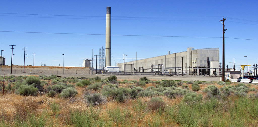 FILE--In this file photo taken June 13, 2017, the Plutonium Uranium Extraction Plant, right, stands adjacent to a dirt-covered rail tunnel, left, containing radioactive waste, amidst desert plants on the Hanford Nuclear Reservation near Richland, Wash. The U.S. Department of Energy said Tuesday, Nov. 14, 2017, that workers have finished stabilizing the partially-collapsed tunnel containing radioactive wastes left over from the production of plutonium for nuclear weapons. (AP Photo/Nicholas K.