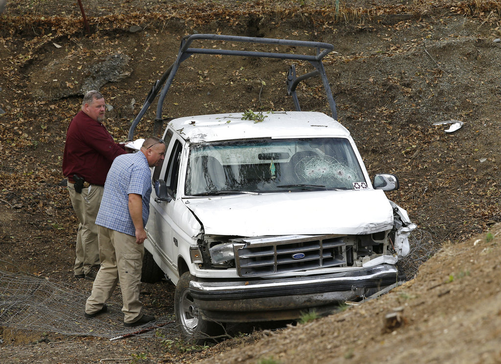 Investigators view a pickup truck involved in a deadly shooting at the Rancho Tehama Reserve, near Corning, Calif., Tuesday, Nov. 14, 2017. A gunman driving stolen vehicles and choosing his targets at random opened fire "without provocation" in the tiny, rural Northern California town Tuesday, killing several people, including a student at an elementary school, before police shot him dead, authorities said.