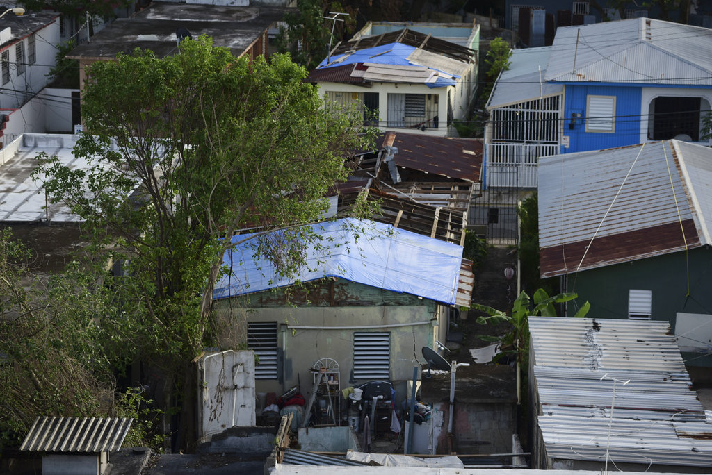In this Nov. 15, 2017 photo, some roofs damaged by Hurricane Maria have awnings installed in El Gandúl neighborhood, in San Juan, Puerto Rico. A newly created Florida company with an unproven record won more than $30 million in contracts from the Federal Emergency Management Agency to provide emergency tarps and plastic sheeting for repairs to hurricane victims in Puerto Rico. Bronze Star LLC never delivered those urgently needed supplies, which even months later remain in demand on the island.