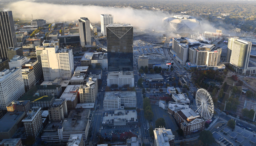 Smoke moves over downtown Atlanta as the Georgia Dome is destroyed in a scheduled implosion, Monday, Nov. 20, 2017. The dome was not only the former home of the Atlanta Falcons but also the site of two Super Bowls, 1996 Olympics Games events and NCAA basketball tournaments among other major events.