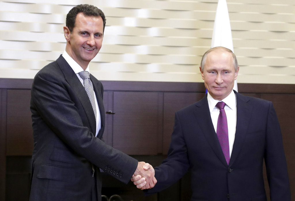 In this photo taken on Monday, Nov. 20, 2017, Russian President Vladimir Putin, right, shakes hand with Syrian President Bashar Assad in the Bocharov Ruchei residence in the Black Sea resort of Sochi, Russia. Russian state TV said the two leaders held bilateral talks on Monday and then met with Russian military chiefs. It was the second time Assad has traveled to Russia to meet with Putin in the course of the country's six-year civil war.