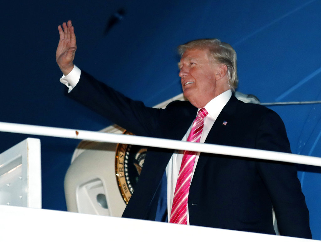 President Donald Trump waves as he steps off Air Force One at the Palm Beach International Airport, Tuesday, Nov. 21, 2017, in West Palm Beach, Fla.