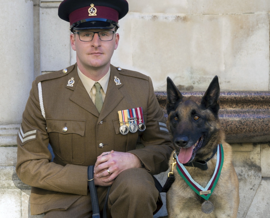 Cpl. Daniel Hatley poses Nov. 17 with Mali, recipient of the Dickin medal for animal bravery.
