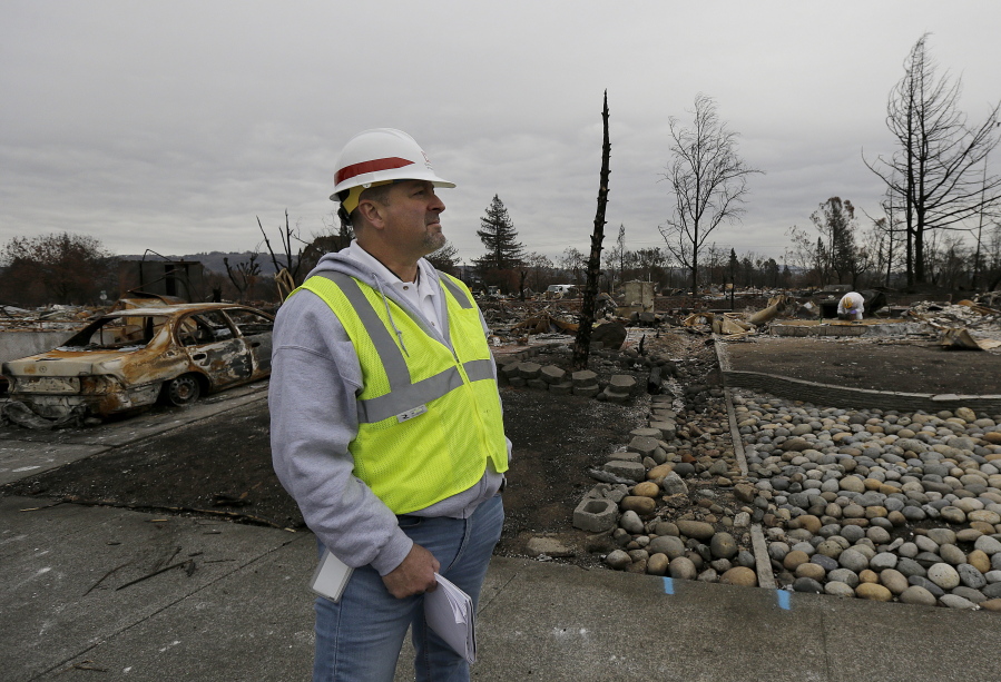 Rick Brown of the U.S. Army Corps of Engineers is interviewed as he watches work crews remove debris a the site of a home destroyed by fires in the Coffey Park area of Santa Rosa, Calif., Wednesday, Nov. 8, 2017. Rumbling front loaders began scraping up the ash and rubble of nearly 9,000 destroyed homes and other structures in Northern California this week as the U.S. Army Corps of Engineers launched a new phase of the largest wildfire clean-up in the state’s history.