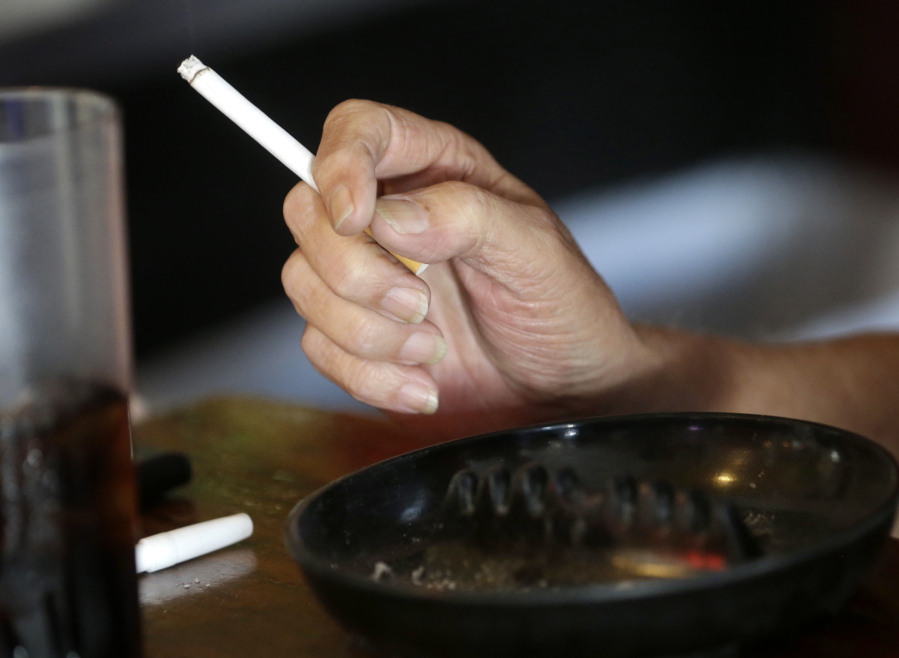 A patron smokes a cigarette inside a bar in New Orleans hours before a smoking ban takes effect in bars, gambling halls and many other public places such as hotels, workplaces, private clubs and stores. Cigarette smoking, over-eating and other unhealthy behaviors can be blamed for nearly half of U.S. cancer deaths each year, according to a new American Cancer Society study released Tuesday, Nov. 21, 2017.
