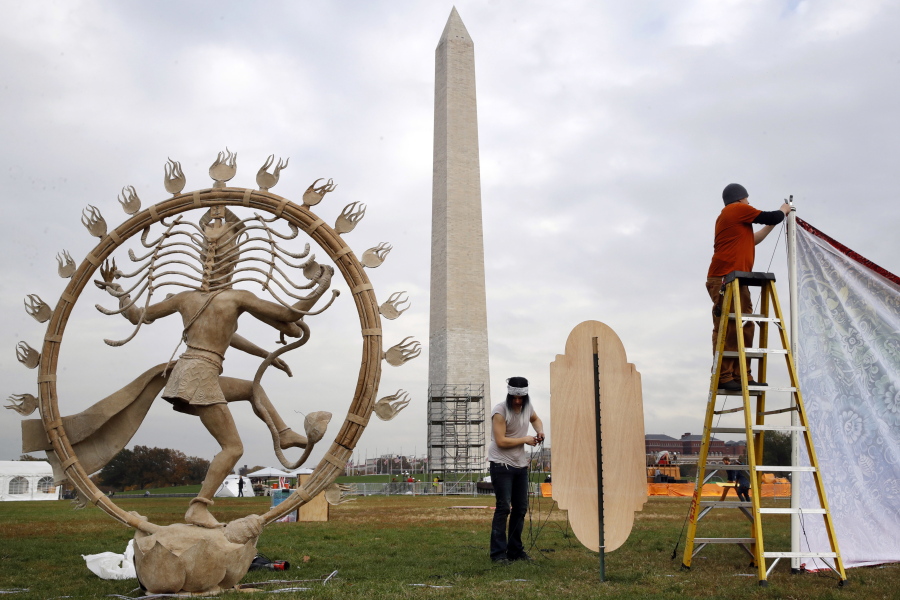 Jaye Brotherton of Jamestown, Colo., center, and Ben Harper, right, work on installation of the “Nataraja” artwork for Catharsis on the Mall, Thursday, Nov. 9, 2017, an event that plans to bring a taste of Burning Man to the National Mall in Washington. The “Nataraja” was a part of last year’s TransFOAMation Camp at Burning Man. The Catharsis on the Mall event begins Friday afternoon and continues through Sunday with round-the-clock, seminars and performances in tents, stages and camps built near the foot of the Washington Monument.