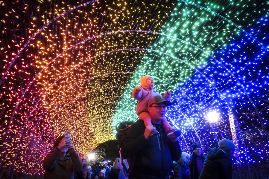 Visitors pass through a tunnel of holiday lights during the Cincinnati Zoo & Botanical Garden Festival of Lights on Nov. 17 in Cincinnati. The festival features 3 million lights.