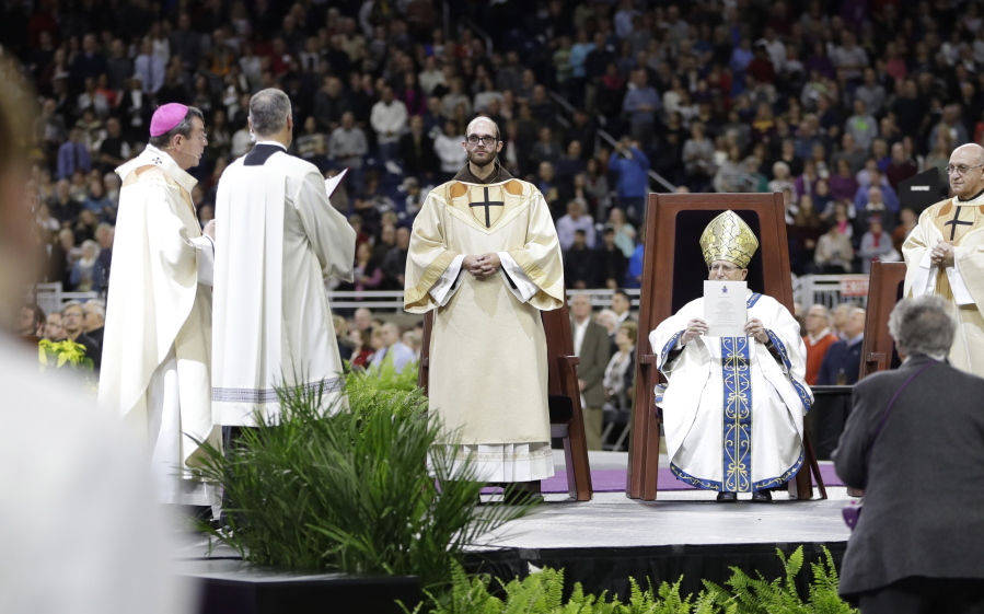 Cardinal Angelo Amato holds the decree of the rite of Beatification for Father Solanus Casey on Saturday at Ford Field in Detroit.