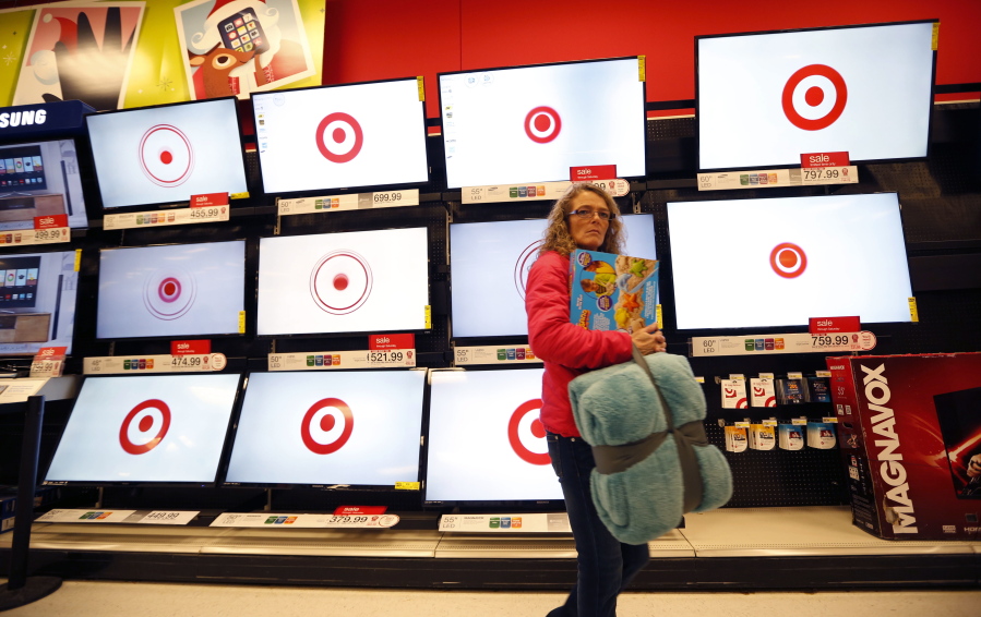 FILE - In this Nov. 28, 2014, file photo, a customer walks past a bank of flat screen televisions at a Target store in South Portland, Maine. Target Corp. reports earnings Wednesday, Nov. 15, 2017. (AP Photo/Robert F.