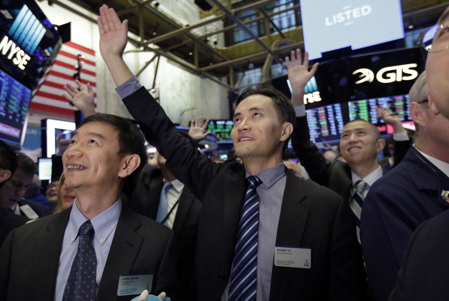 Jianpu Technology’s co-founder & CEO Daqing Ye, center, waves to a gallery in the New York Stock Exchange as he waits for his company’s IPO to begin trading, Thursday, Nov. 16, 2017.
