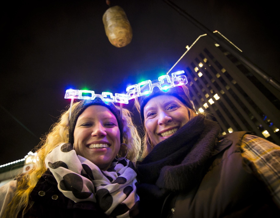FILE--In this Dec. 31, 2014, file photo, Shelby Besler left, and her mother Tracey Besler, smile for a photograph on New Year’s Eve as revelers ring in 2015 with the second annual Idaho Potato Drop in downtown Boise, Idaho. The Idaho Potato Commission has upped its sponsorship to $50,000 for the event, where a giant potato drops out of the sky as a countdown to the new year, that’s now in its fifth year and keeps gaining more attention.