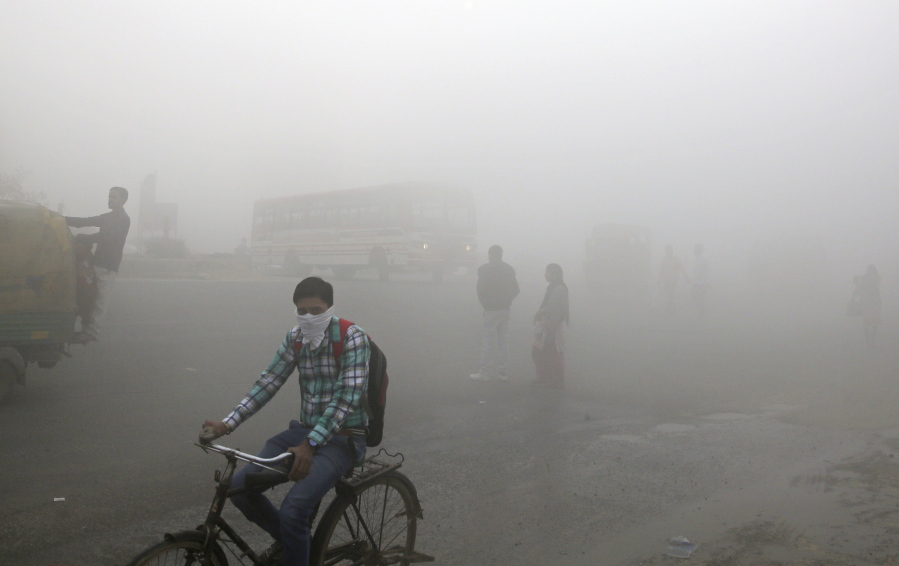 Indian commuters wait for transport amid thick blanket of smog on the outskirts of New Delhi, India, Friday. As air pollution peaked this week in Delhi, it rose to more than 30 times the World Health Organization’s recommended safe level. Experts have compared it to smoking a couple of packs of cigarettes a day. A recent report by the Lancet medical journal estimated that a quarter of all premature deaths in India, some 2.5 million each year, are caused by pollution.
