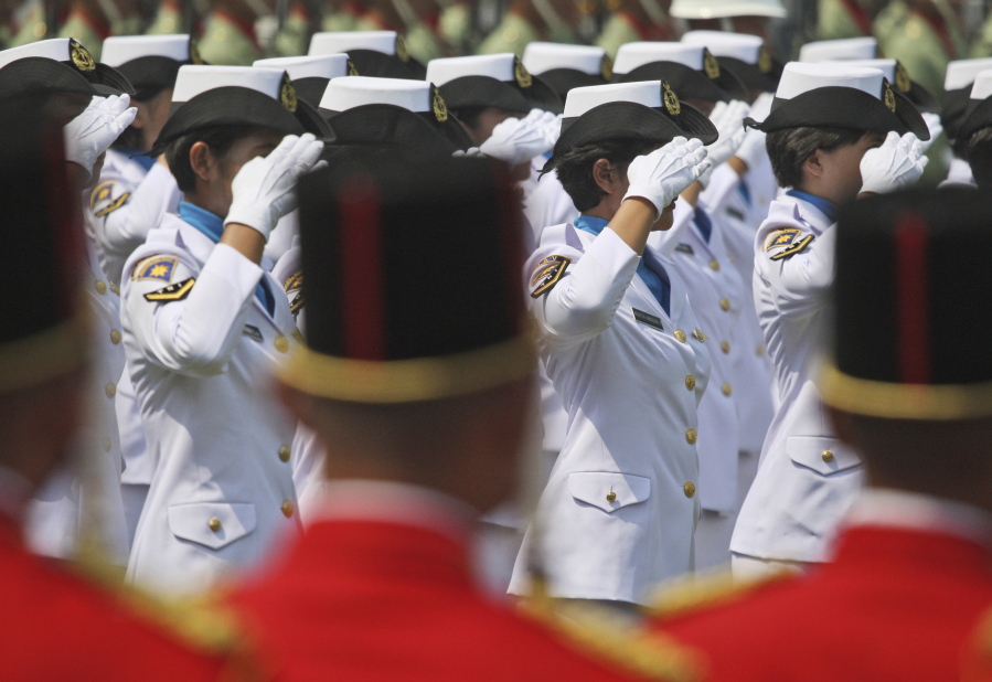 In this Aug. 17, 2012 photo, female members of Indonesian Navy salute during a ceremony commemorating the Independence Day at Merdeka Palace in Jakarta, Indonesia. Indonesia’s military and police continue to perform abusive virginity tests on female recruits three years after the World Health Organization declared they had no scientific validity, an international human rights group said Wednesday, Nov. 22, 2017.