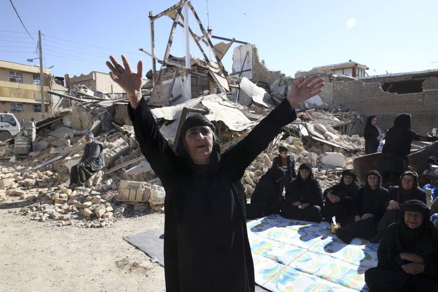 A woman mourns at an earthquake site in Sarpol-e-Zahab in western Iran on Tuesday. Rescuers are digging through the debris of buildings felled by the Sunday earthquake in the border region of Iran and Iraq.