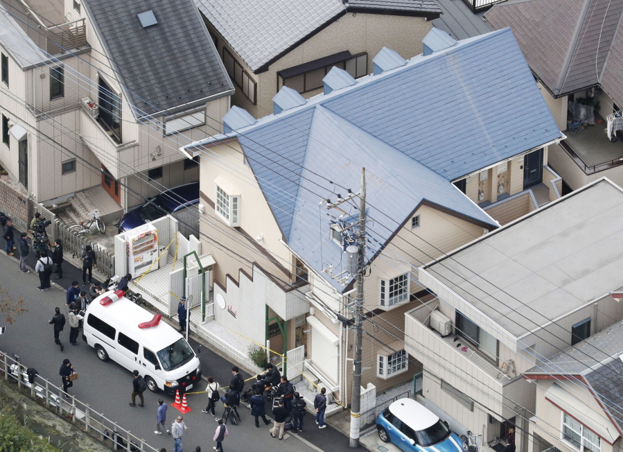 The apartment, center, where police found dismembered bodies in coolers in Zama city, southwest of Tokyo, on Tuesday. A police spokesman said Tuesday the 27-year-old suspect confessed to cutting up the bodies and hiding them in cold-storage cases, covered with cat litter.