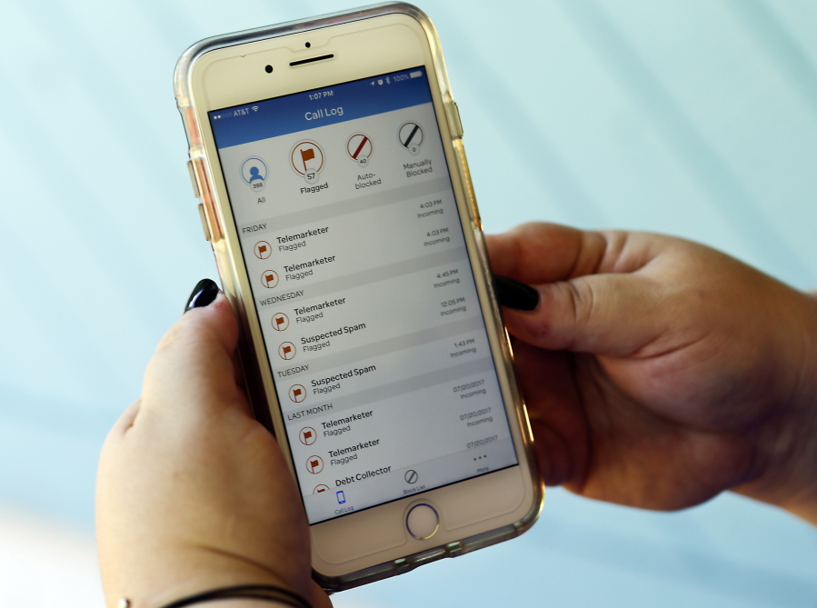 Jen Vargas looks at a call log displayed via an AT&T app on her cellphone at her home in Orlando, Fla. The app helps locate and block fraudulent calls although some robocalls still get through.