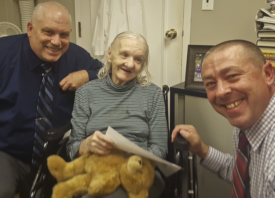 Flora Harris, center, with Sullivan County Sheriff’s Detective Sgt. Ed Clouse, left, and Detective Rich Morgan at an assisted living residence in Lowell, Mass. Harris, who disappeared from upstate New York in 1975, has been found suffering from dementia and living in the assisted-living facility in Massachusetts, authorities said. Officials said they’ve been unable to figure out details of what happened to her between the time she disappeared and when she was finally found.
