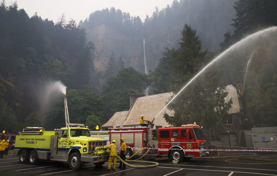 Firefighters keep watch Sept. 6 at the Multnomah Falls Lodge as the Eagle Creek Fire burns in the Columbia River Gorge.