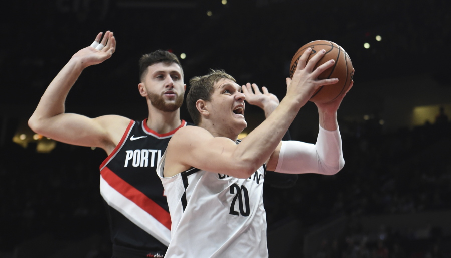 Brooklyn Nets center Timofey Mozgov drives to the basket on Portland Trail Blazers center Jusuf Nurkic during the first half of an NBA basketball game in Portland, Ore., Friday, Nov. 10, 2017.