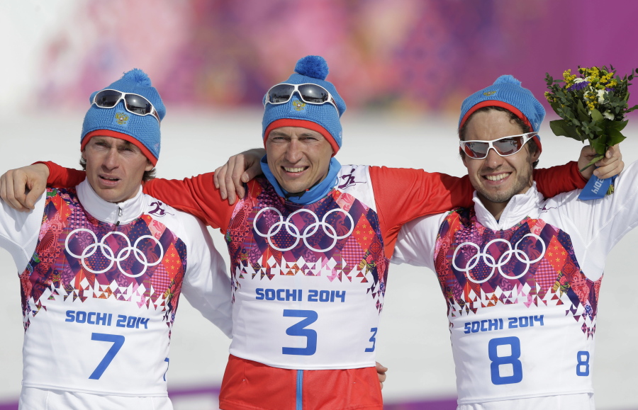 Russia’s gold medal winner Alexander Legkov is flanked by Russia’s silver medal winner Maxim Vylegzhanin, left and Russia’s bronze medal winner Ilia Chernousov during the flower ceremony of the men’s 50K cross-country race at the 2014 Winter Olympics, in Krasnaya Polyana, Russia. Four more Russian cross-country skiers have been found guilty of doping at the 2014 Sochi Olympics, it was announced on Thursday, Nov. 9, 2017 including silver medalist Maxim Vylegzhanin.