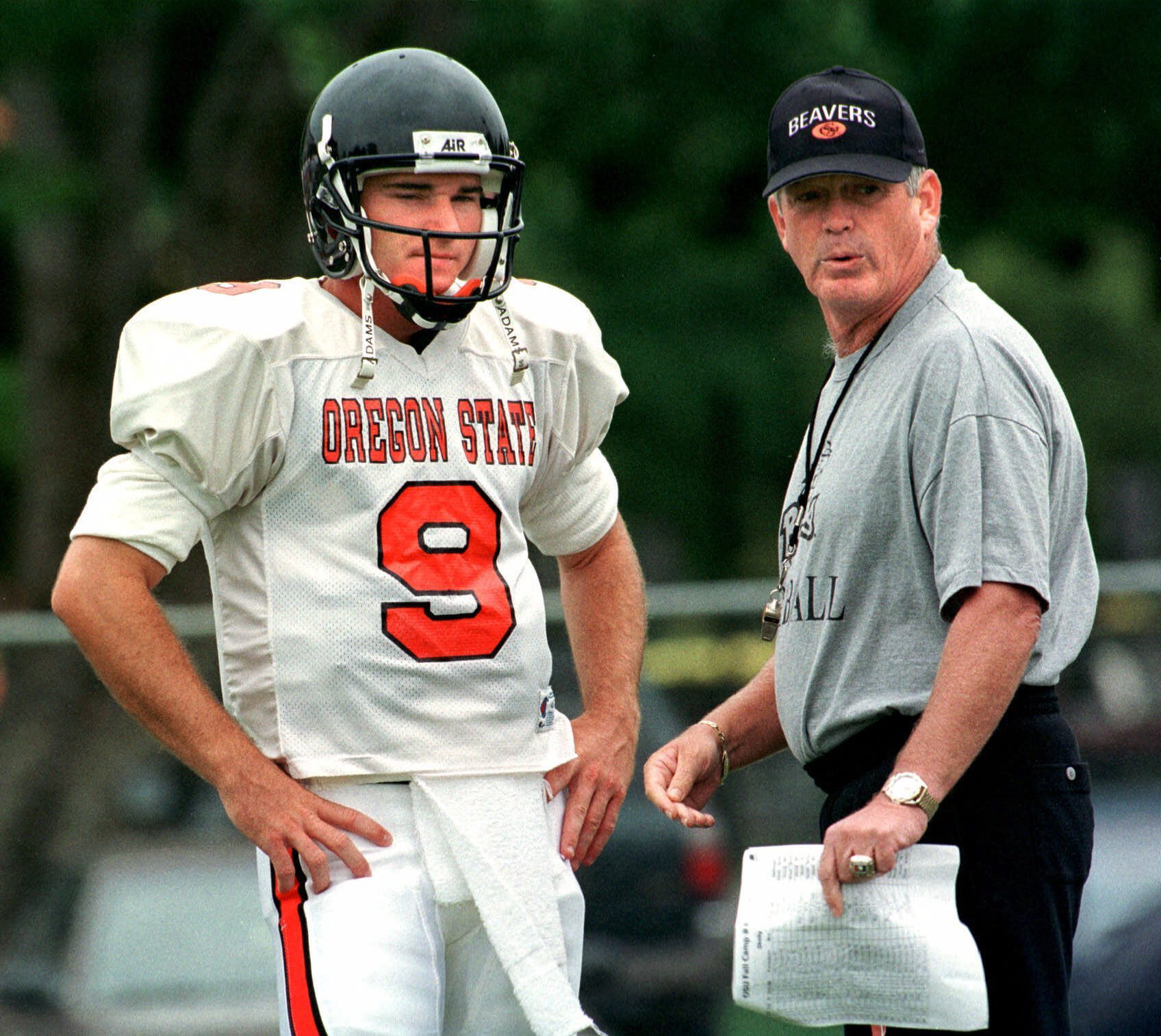 In this Wednesday, Aug. 18, 1999 file photo, Oregon State head football coach Dennis Erickson talks strategy with quarterback Jonathan Smith during practice in Corvallis, Ore. A person with direct knowledge of the decision says Oregon State has hired Washington co-offensive coordinator Jonathan Smith to be its new head coach. The person spoke to The Associated Press on Wednesday, Nov. 29, 2017 on condition of anonymity because an official announcement was being finalized.