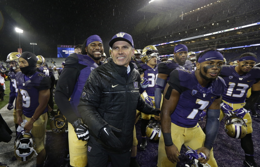 Washington head coach Chris Petersen, center, leads his team off the field after they beat Oregon 38-3 in an NCAA college football game, Saturday, Nov. 4, 2017, in Seattle. Washington won, 38-3. (AP Photo/Ted S.