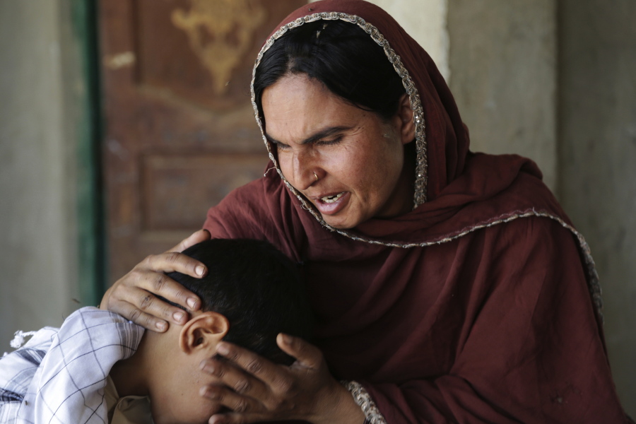 Kausar Parveen comforts her child who was allegedly raped by a mullah or religious cleric, in Kehror Pakka, Pakistan. The Associated Press interviewed more than a dozen children or relatives of children who had been sexually assaulted by a maulvi or cleric at the madrassa where they studied. (AP Photo/K.M.