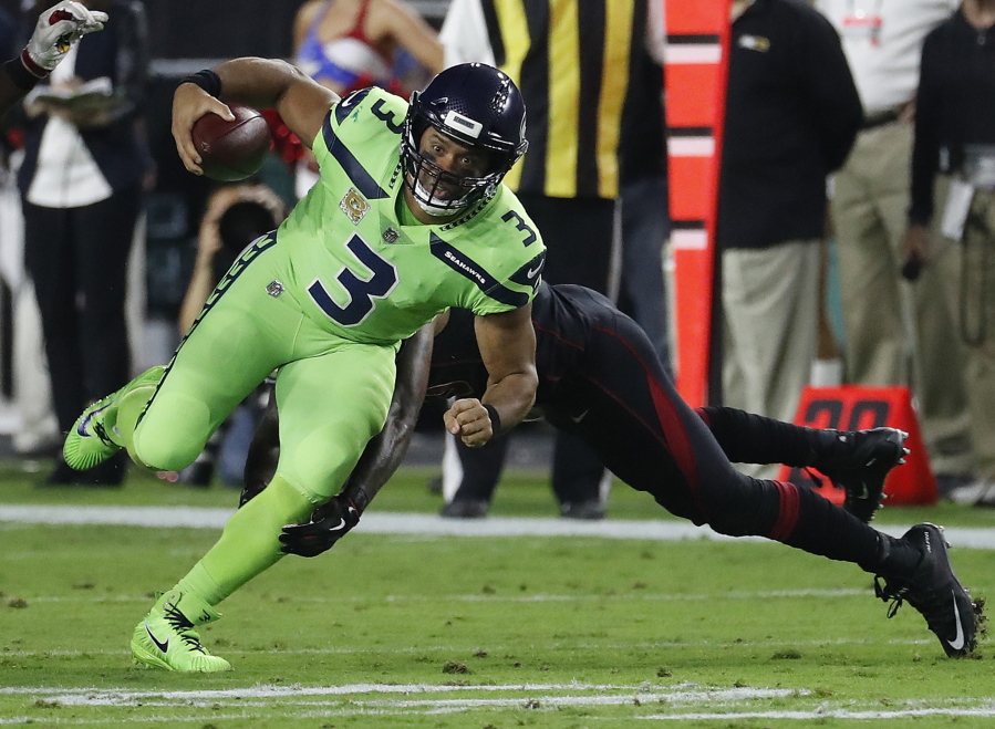 Seattle Seahawks quarterback Russell Wilson (3) eludes the tackle agasint the Arizona Cardinals during the first half of an NFL football game, Thursday, Nov. 9, 2017, in Glendale, Ariz.