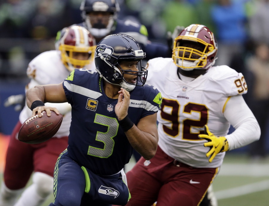 FILE - In this Sunday, Nov. 5, 2017, file photo, Seattle Seahawks quarterback Russell Wilson (3) scrambles away from Washington Redskins defensive end Stacy McGee (92) in the second half of an NFL football game in Seattle. The Seahawks are favored again when they face the Arizona Cardinals on Thursday night.