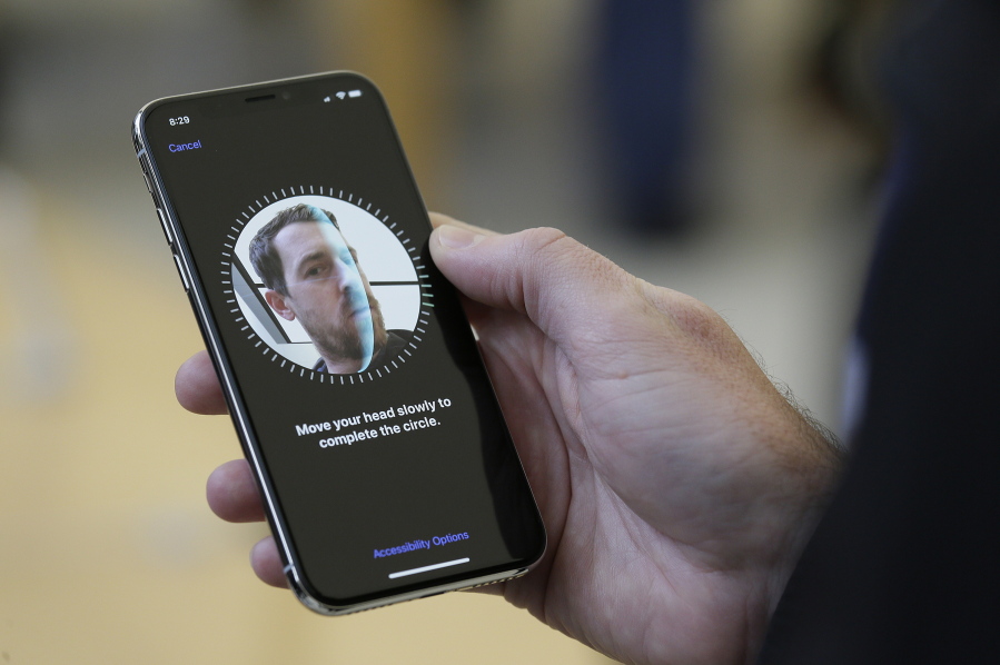 An Apple employee demonstrates the facial recognition feature of the new iPhone X at the Apple Union Square store in San Francisco.