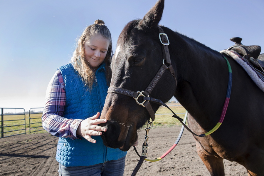 Abby Glenn, a student of Solid Ground Equine Assisted Therapy, pets the nose of Cash, a therapy horse, at the Griffith Ranch in Klamath Falls, Ore.