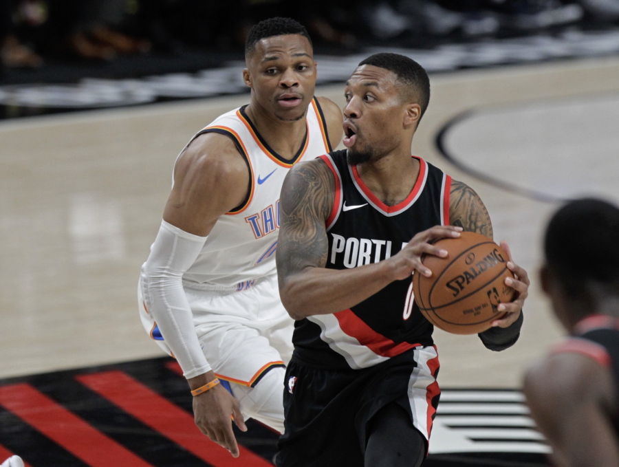 Portland Trail Blazers guard Damian Lillard, right, looks to pass as Oklahoma City Thunder guard Russell Westbrook defends during the first half of an NBA basketball game in Portland, Ore., Sunday, Nov. 5, 2017.