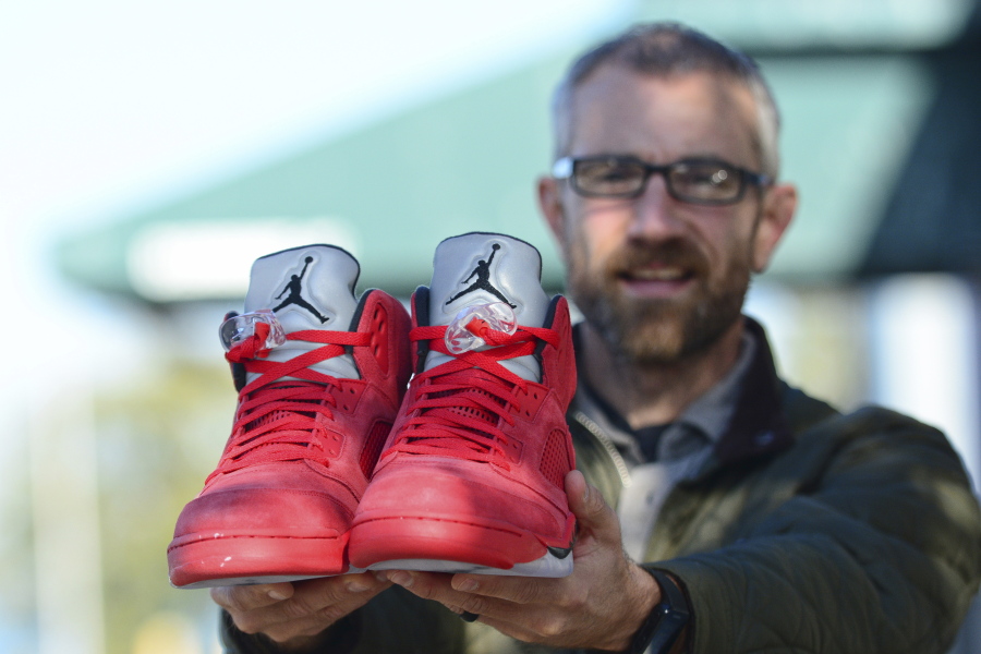 The Rev. Joe DeScala holds up a pair of limited-edition Air Jordan shoes.
