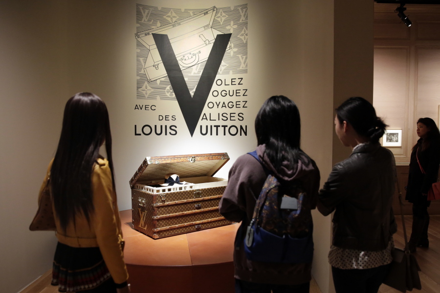 Visitors view a 1906 trunk, displayed as part of the “Volez, Voguez, Voyagez,” Louis Vuitton exhibit in the former American Stock Exchange building, in New York financial district. The luxury French brand was founded in the mid-19th century.