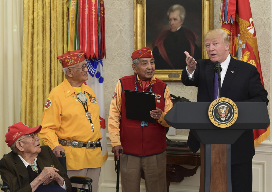 President Donald Trump, right, speaks during a meeting with Navajo Code Talkers including Fleming Begaye Sr., seated left, Thomas Begay, second from left, and Peter MacDonald, second from right, in the Oval Office of the White House in Washington on Monday.