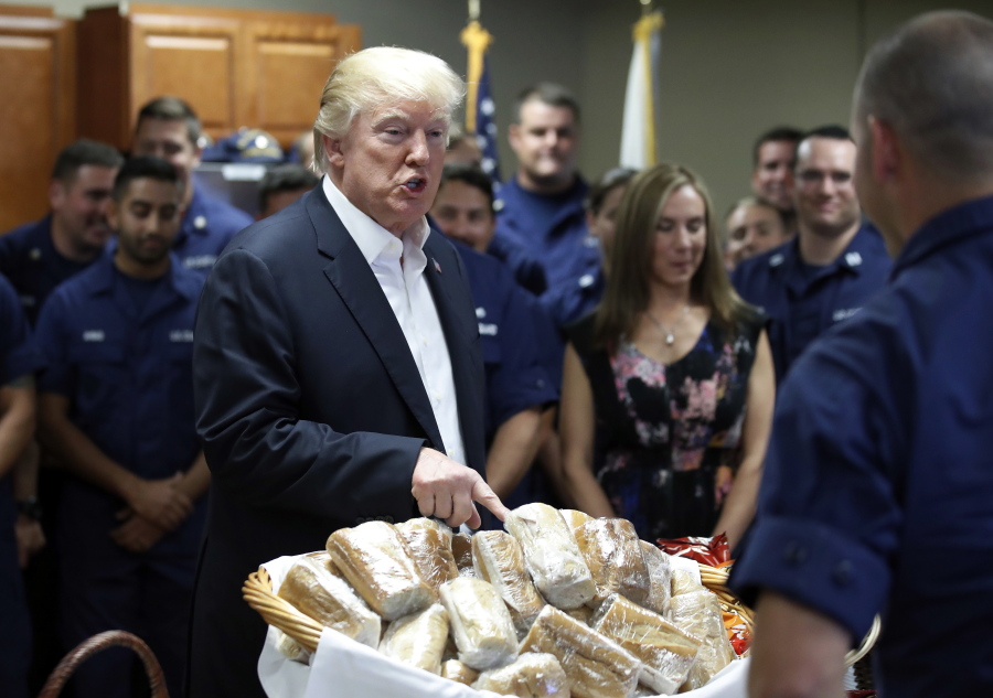 President Donald Trump prepares to hand out sandwiches to members of the U.S. Coast Guard at the Lake Worth Inlet Station, on Thanksgiving on Thursday in Riviera Beach, Fla.
