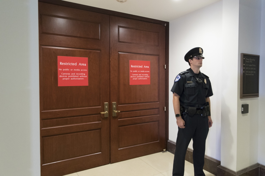 In this July 25, 2017 photo, a U.S. Capitol Police office stands guard outside a secure area in the basement of the Capitol in Washington, where the House Intelligence Committee has been conducting interviews. The House intelligence committee is preparing to interview Russian-American lobbyist Rinat Akhmetshin, who attended a meeting at Trump Tower last year with President Donald Trump’s son, and Attorney General Jeff Sessions, according to people familiar with the interviews. (AP Photo/J.