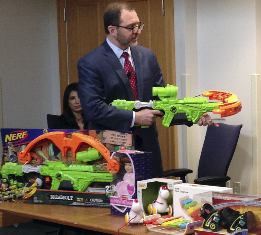 James Swartz, director of World Against Toys Causing Harm, or WATCH, displays Nerf’s “Zombie Strike” crossbow during a news conference Tuesday in Boston, where the child safety group released its annual holiday list of the 10 most hazardous toys.