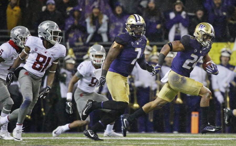 Washington defensive back Ezekiel Turner, right, runs with the ball after he intercepted a Washington State pass during the first half of an NCAA college football game, Saturday, Nov. 25, 2017, in Seattle. (AP Photo/Ted S.